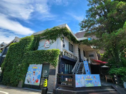 a ivy covered house with a sign in front of it at OkiDoki House in Seoul