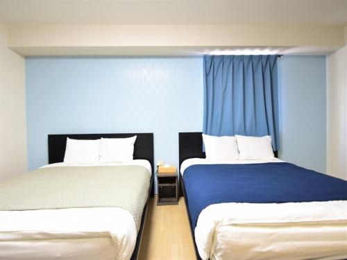 2 camas en una habitación con paredes azules en Regariain - Vacation STAY 84909, en Okayama