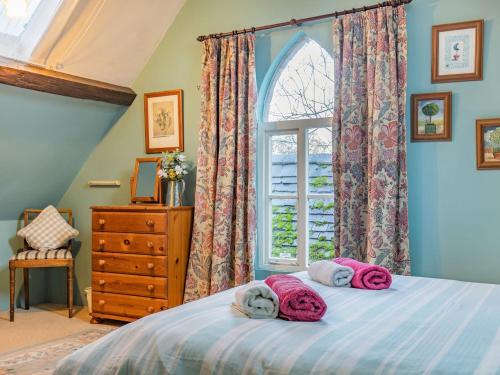 a bedroom with a bed with pink towels on it at The Saddlery in Shirley