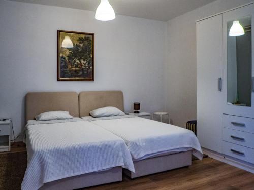 1 dormitorio con 1 cama y una pintura en la pared en Apartment Dubovac, en Karlovac