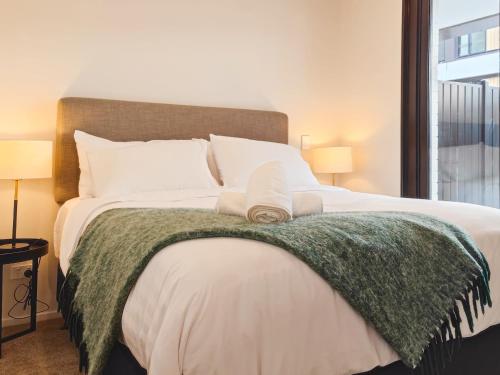1 dormitorio con 1 cama grande con manta verde en Luxurious 2 bedroom apartment Free secure parking, en Auckland