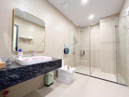 a bathroom with a sink and a shower and a toilet at Lam's Beach Homestay in Phan Thiet