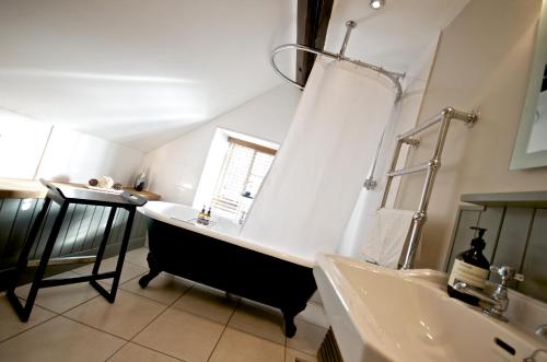 a bathroom with a bath tub and a sink at Stunning Yew Tree Cottage in Westow