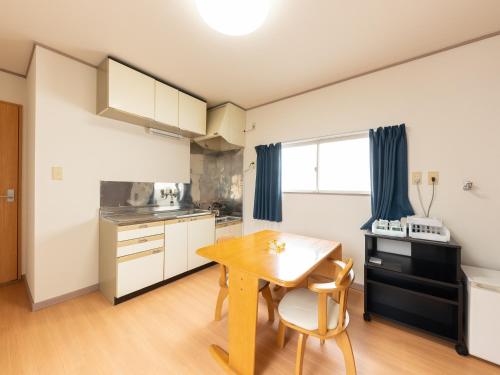 a kitchen with a table and chairs in a room at Tabist My Room Tagajjo in Tagajo