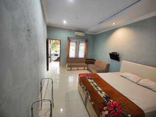 a bedroom with a bed and a living room at Pondok Dewi in Pangandaran