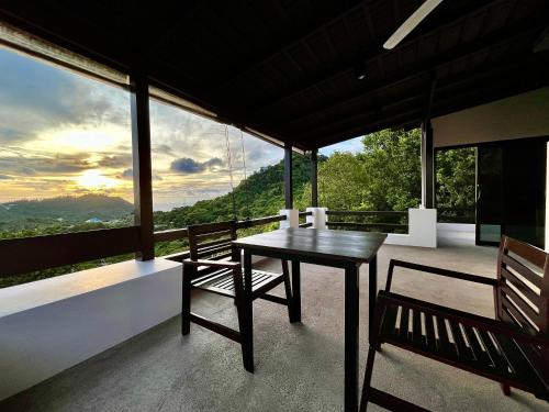 a table and chairs on a balcony with a view at KohTao Studios Sunset in Koh Tao