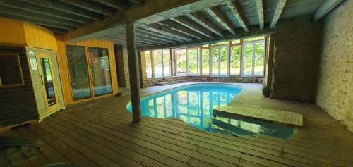 ein Haus mit einem Pool auf einer Holzterrasse in der Unterkunft Moulin Chantepierre in Pont-dʼHéry