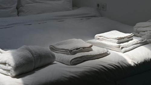 Una cama blanca con toallas encima. en Clock Tower en Arachova