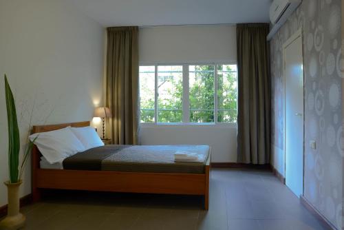 a bedroom with a bed and a large window at Mathurin Appartementen in Paramaribo