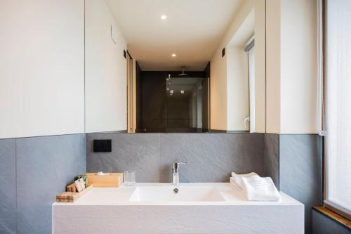 Bihotel في Comerzo: حمام مع حوض أبيض ومرآة