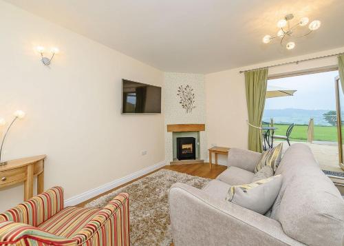 a living room with a couch and a fireplace at Larkshayes Cottages in Hawley Bottom