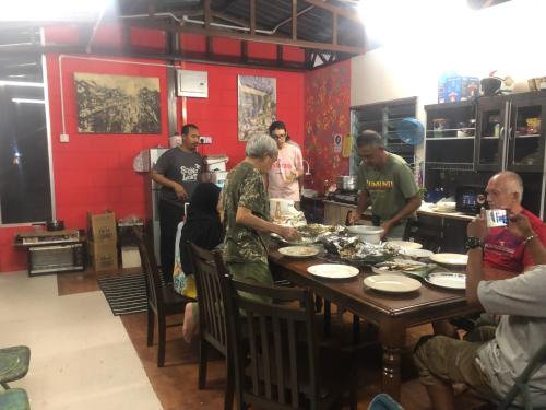 a group of people standing around a table preparing food at MyDusun Chalet, Taiping, Perak, Malaysia in Taiping