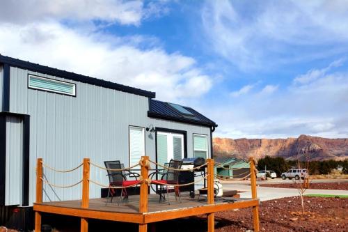 a tiny house with a deck with a table and chairs at Charming Tiny Home with private deck and bbq in Apple Valley