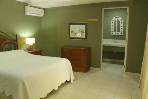 a bedroom with a bed and a bathroom with a sink at Puerto Barillas in Bahia de Jiquilisco