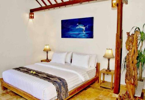 1 dormitorio con 1 cama blanca y 2 lámparas en Villa Serene & Spa Mangsit, en Mangsit