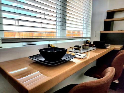 a wooden table with two bowls on top of it at Designer Modern Tiny Home w All of The Amenities in Apple Valley