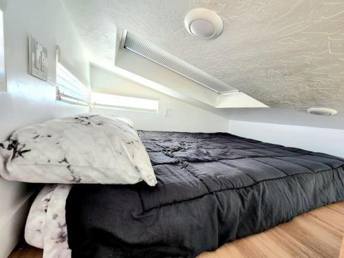 a bedroom with a black bed in a room at Designer Modern Tiny Home w All of The Amenities in Apple Valley