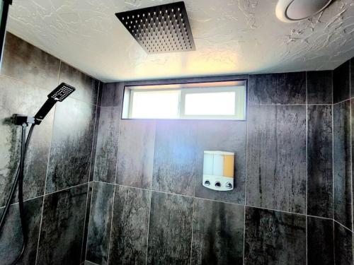 baño con ducha y ventana en Designer Modern Tiny Home w All of The Amenities en Apple Valley