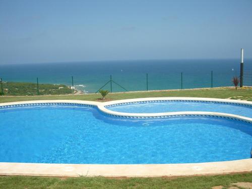 a swimming pool with the ocean in the background at Benicassim Lujo in Benicàssim