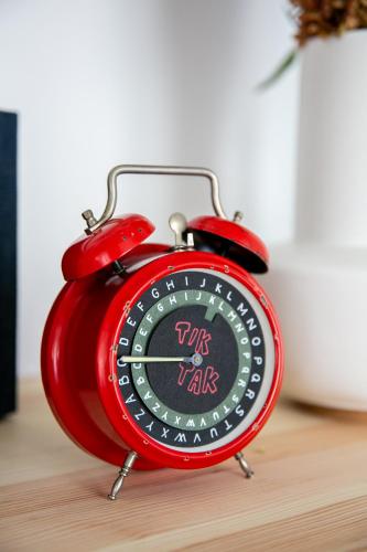 a red alarm clock sitting on top of a table at Kikapcsol-LAK in Bogács