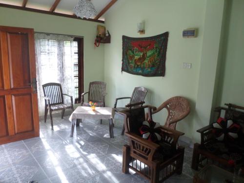 a room with chairs and a table and a painting on the wall at Grand Nest Bay Resort in Weligama