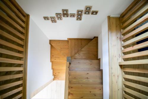 a wooden staircase in a house with white walls and wooden floors at Kikapcsol-LAK in Bogács