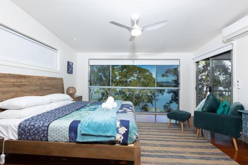 - une chambre avec un lit et une grande fenêtre dans l'établissement Binnowee Lakeside - Between the ocean and lake, à Tiona