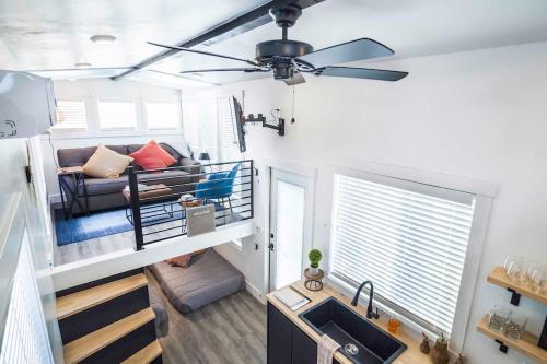a living room with a couch and a ceiling fan at New modern & relaxing Tiny House w deck near ZION in Apple Valley