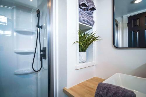 y baño con ducha, lavabo y espejo. en New modern & relaxing Tiny House w deck near ZION en Apple Valley