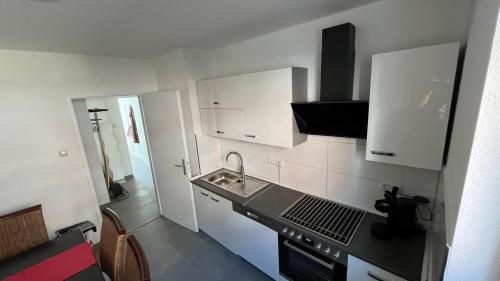 a small kitchen with white cabinets and a sink at Charaktervolle Whg. mitten in Kassel inkl.Parkplatz in Kassel