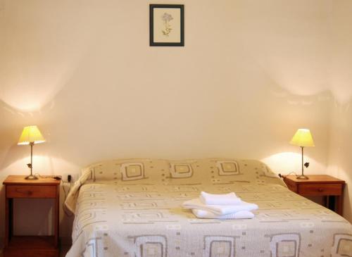 a bedroom with a white bed with two lamps at Cabañas Donkaia in La Población