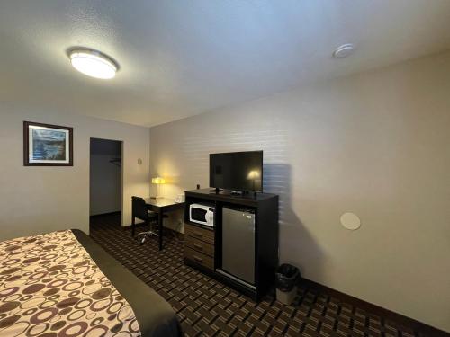 ein Hotelzimmer mit einem Bett und einem Flachbild-TV in der Unterkunft Beverly Lodge in South Lake Tahoe