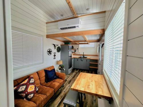uma sala de estar com um sofá e uma mesa em Romantic Tiny home with private deck em Apple Valley
