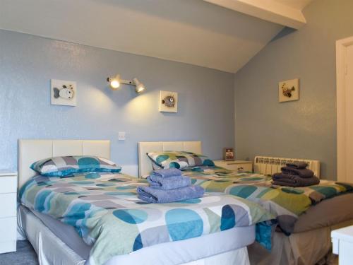 a bedroom with two beds with towels on them at Dolphin Cottage in Grange Over Sands