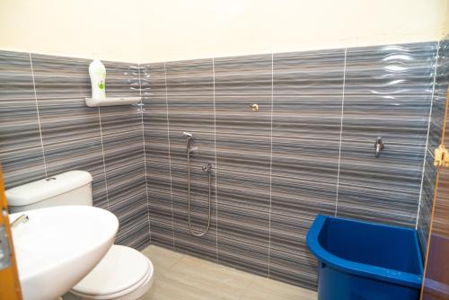 a bathroom with a toilet and a shower at Adorable 3-bedroom home with Wi-Fi, Netflix and BBQ grill in Rembau