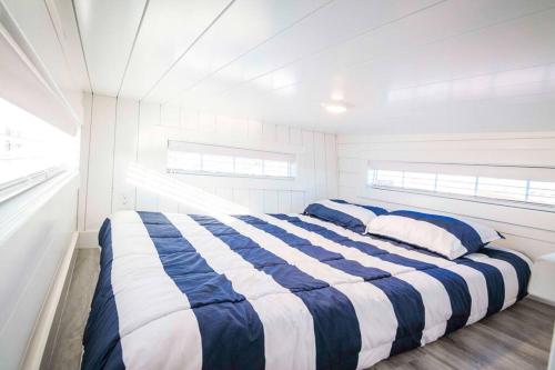 a bedroom with a blue and white striped bed at Zion Stay, Scenic Tiny Home & Sunset Views in Apple Valley