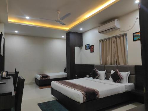a hotel room with a bed and a television at Hotel Paradise - Biswanath Chariali in Bishnāth