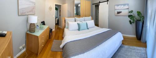 a bedroom with a large bed with white and blue pillows at The Hutt on Mandurah Marina in Mandurah