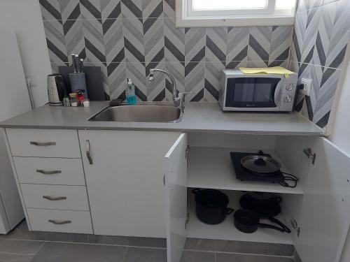 a kitchen with a sink and a microwave at Villa Vered in Eilat