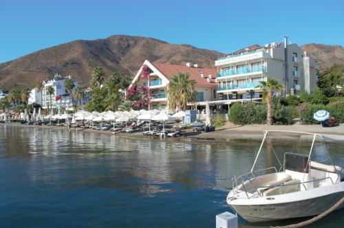 a boat sitting in the water next to a resort at Örsmaris Boutique Hotel in Marmaris