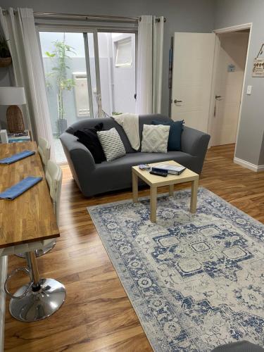 a living room with a couch and a coffee table at The Hutt on Mandurah Marina in Mandurah