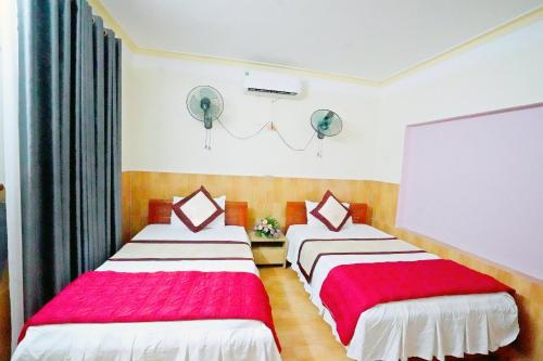 a bedroom with two beds with red and white sheets at New Nhat Minh HomeStay in Ninh Binh