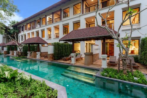 a hotel with a swimming pool in front of a building at JW Marriott Phuket Resort and Spa in Mai Khao Beach