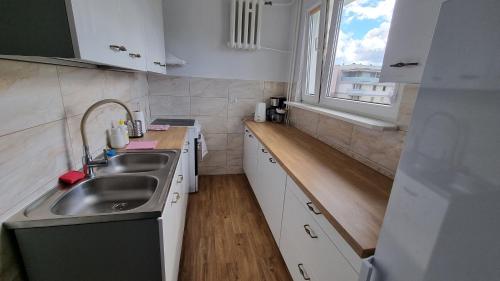 a small kitchen with a sink and a window at Apartament Okno na Zamek in Malbork