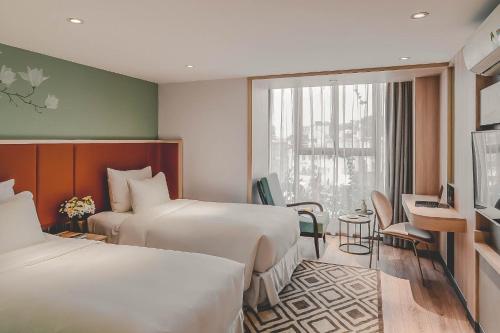 Ένα ή περισσότερα κρεβάτια σε δωμάτιο στο Hanoi Le Jardin Hotel & Spa