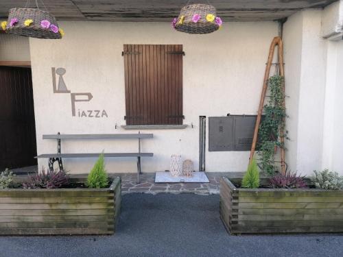 a building with two potted plants and a bench at Casa vacanze 'La piazza' in Zone