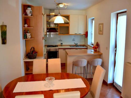 eine Küche mit einem Holztisch und weißen Stühlen in der Unterkunft Apartment Take a Look in Dajla