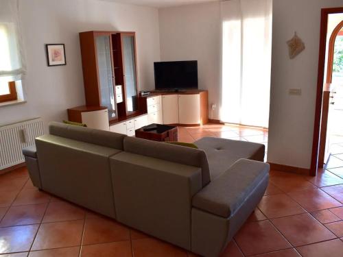 ein Wohnzimmer mit einem Sofa und einem TV in der Unterkunft Apartment Take a Look in Dajla