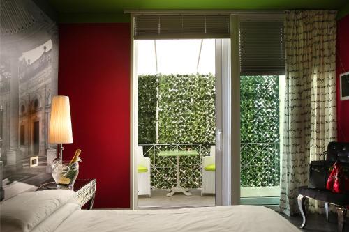 a bedroom with a bed and a sliding glass door at Adua & Regina di Saba Wellness & Beauty in Montecatini Terme