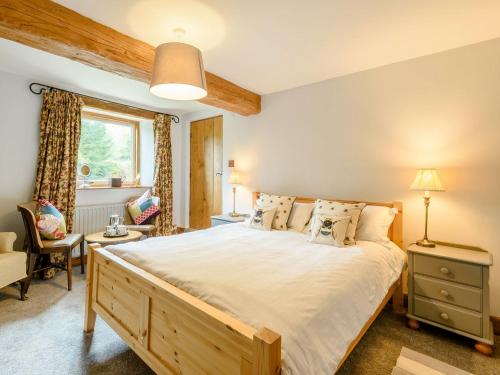 a bedroom with a large bed and a chair at Loadbrook Barn in Ughill